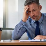 ejecutivo hombre agobiado por el trabajo representando el burnout
