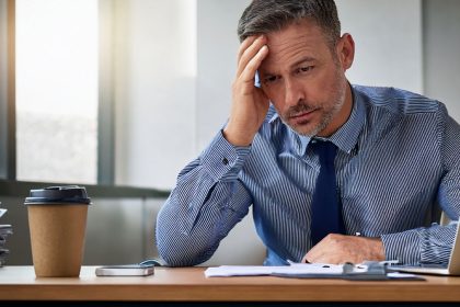 ejecutivo hombre agobiado por el trabajo representando el burnout