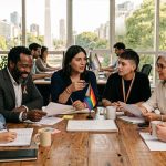 equipo de trabajo diverso en oficina de coworking reunidos a la mesa durante el mes del orgullo