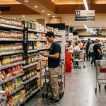 Profesional verificando productos y disponibilidad en góndola dentro de un supermercado, representando la importancia de una correcta ejecución en el punto de venta para evitar errores comunes en Trade Marketing