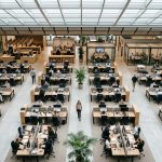 Oficina moderna con equipos distribuidos colaborando en diferentes áreas, representando la escalabilidad y flexibilidad que aporta el Recruitment Process Outsourcing (RPO) a los procesos de contratación