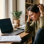 Persona revisando su currículum frente a una computadora durante una búsqueda de empleo, representando errores comunes que pueden dificultar la inserción laboral.