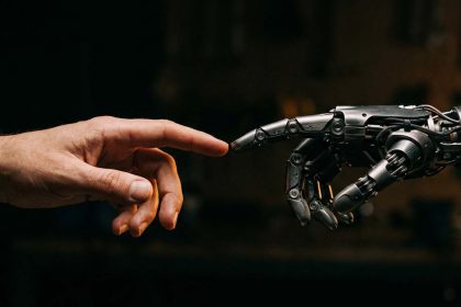 Mano humana y mano robótica acercándose como símbolo de la colaboración entre personas e inteligencia artificial, para ilustrar los nuevos empleos generados por la IA.